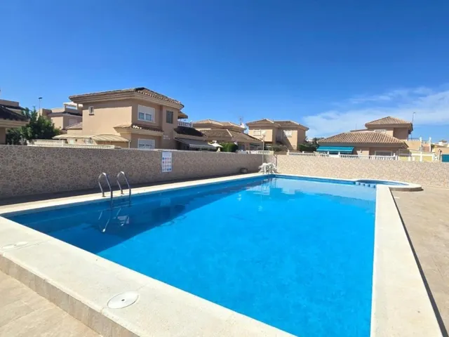 Amplia villa (aprox. 98 m2 + terrazas y garaje) con 3 dormitorios, 2 baños y gran piscina comunitaria. Cerca de colegios y comercios, y a solo 1,5 km de las playas de Punta Prima. — 47