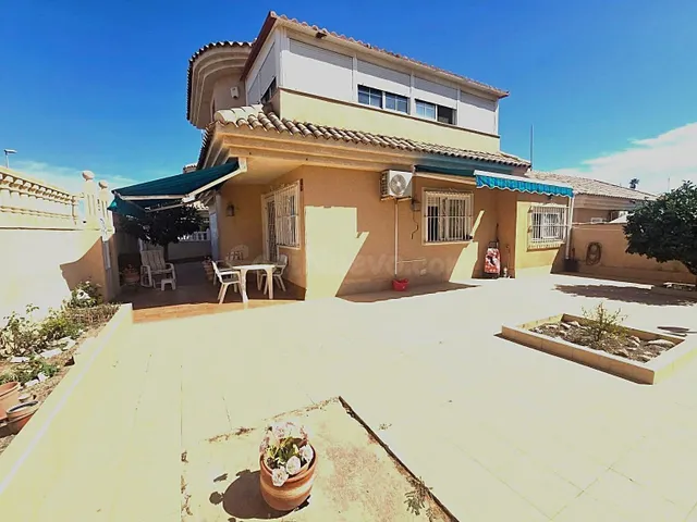 Amplia villa (aprox. 98 m2 + terrazas y garaje) con 3 dormitorios, 2 baños y gran piscina comunitaria. Cerca de colegios y comercios, y a solo 1,5 km de las playas de Punta Prima. — 2