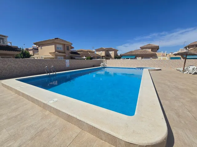 Amplia villa (aprox. 98 m2 + terrazas y garaje) con 3 dormitorios, 2 baños y gran piscina comunitaria. Cerca de colegios y comercios, y a solo 1,5 km de las playas de Punta Prima. — 48