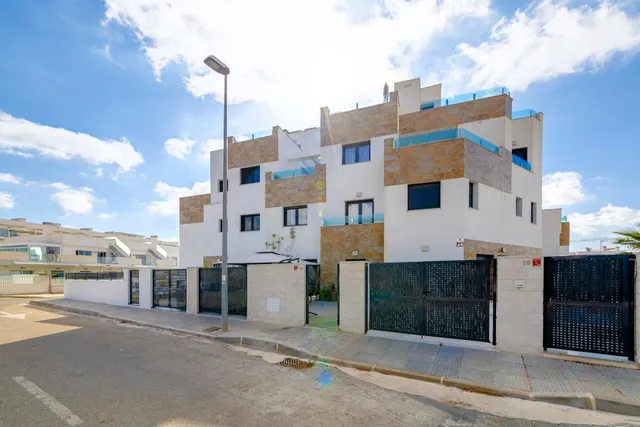 Casa adosada moderna y espaciosa (aprox. 116 m2) con 3 dorm, 3 baños, varias terrazas, y gran piscina comunitaria. Cerca de campos de golf, La Zenia Boulevard, y a poco más de 5 km de las playas. — 36